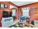 Cozy home office with terracotta-colored walls, desk, sofa, colorful rug, and ample storage space at 10924 Archway Ave, Hudson, FL 34667