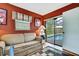 Home office featuring a sofa, vibrant rug, and access to a screened-in pool area with clear sliding glass doors at 10924 Archway Ave, Hudson, FL 34667