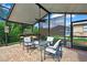 Relaxing screened patio with a ceiling fan, table, chairs, and a bar area, perfect for outdoor entertaining at 10924 Archway Ave, Hudson, FL 34667