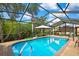 Relaxing screened pool area with bar, outdoor seating, and lush landscaping perfect for enjoying outdoor living at 10924 Archway Ave, Hudson, FL 34667