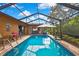 Inviting screened pool featuring clear, refreshing water, surrounded by a brick patio and lush landscaping at 10924 Archway Ave, Hudson, FL 34667
