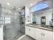 Stylish bathroom with glass enclosed shower, double sink vanity, and a large mirror at 10060 Chip Ln, New Port Richey, FL 34654