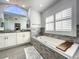 Bright bathroom features a soaking tub with stone surround, double sink vanity, and neutral color palette at 10060 Chip Ln, New Port Richey, FL 34654