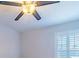 Simple bedroom with a ceiling fan and window with plantation shutters at 10060 Chip Ln, New Port Richey, FL 34654