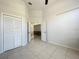 Bedroom with vaulted ceilings, closet, and tile flooring. View to living space at 10060 Chip Ln, New Port Richey, FL 34654