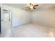 A spacious bedroom with neutral walls and tile flooring features a modern ceiling fan at 10060 Chip Ln, New Port Richey, FL 34654