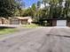 Exterior showing garages with multiple bays and car port surrounded by grass and paved driveway at 10060 Chip Ln, New Port Richey, FL 34654