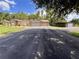 Spacious home with a long driveway leading to a three-car garage and separate storage shed at 10060 Chip Ln, New Port Richey, FL 34654