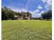 Wide view of home with lush front lawn and mature trees showcasing curb appeal at 10060 Chip Ln, New Port Richey, FL 34654