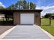 Garage featuring an overhead door and lean to for parking and storage at 10060 Chip Ln, New Port Richey, FL 34654