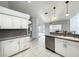 This kitchen has white cabinets, tile floors, and gray countertops with views of the pool at 10060 Chip Ln, New Port Richey, FL 34654