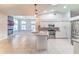 Modern kitchen with stainless steel appliances, white cabinetry, and an open view to the living room at 10060 Chip Ln, New Port Richey, FL 34654