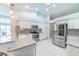 Bright kitchen features stainless steel appliances, white cabinetry, an island with bar seating, and tile flooring at 10060 Chip Ln, New Port Richey, FL 34654