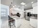 Bright kitchen features stainless steel appliances, white cabinetry, an island with bar seating, and tile flooring at 10060 Chip Ln, New Port Richey, FL 34654
