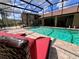 Enjoy the outdoors with this screened-in pool, surrounded by brick pavers and lounge chairs at 10060 Chip Ln, New Port Richey, FL 34654