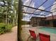 Relaxing backyard with a screened pool, comfortable seating, and a manicured yard with mature trees at 10060 Chip Ln, New Port Richey, FL 34654