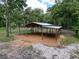 Aerial view of the open barn, framed by dense trees under a bright sky at 10097 Weatherly Rd, Brooksville, FL 34601