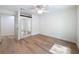 Bright bedroom with wood floors, ceiling fan, and mirrored closet doors offers a spacious and modern feel at 10097 Weatherly Rd, Brooksville, FL 34601