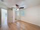 Light-filled bedroom boasts wood floors, a ceiling fan, and mirrored closet doors offering a modern touch at 10097 Weatherly Rd, Brooksville, FL 34601