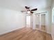 Bedroom with hardwood floors, fan and sliding mirrored closet doors at 10097 Weatherly Rd, Brooksville, FL 34601