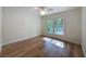 Bright bedroom features hardwood floors and a ceiling fan with a wooded view at 10097 Weatherly Rd, Brooksville, FL 34601