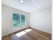 Sunlit bedroom with light colored wood floors and large window at 10097 Weatherly Rd, Brooksville, FL 34601