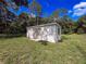 View of white detached garage, accentuated by lush grass under a partly cloudy sky at 10097 Weatherly Rd, Brooksville, FL 34601