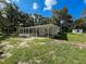 Backyard view features a screened patio, an open yard and a detached storage shed at 10097 Weatherly Rd, Brooksville, FL 34601