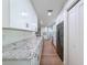 Long kitchen with stainless steel appliances, granite counters and white cabinets at 10097 Weatherly Rd, Brooksville, FL 34601