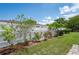 Landscaped backyard with a lush green lawn, decorative flowerbeds and white fencing at 10600 Oleander Dr, Port Richey, FL 34668