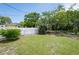 Secluded backyard oasis featuring mature trees and a white picket fence at 10600 Oleander Dr, Port Richey, FL 34668