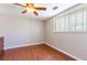 Inviting bedroom featuring wood-look floors, neutral colors, ceiling fan and natural light at 10600 Oleander Dr, Port Richey, FL 34668