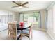 Bright dining room featuring a modern ceiling fan, table for six, and view to the backyard at 10600 Oleander Dr, Port Richey, FL 34668