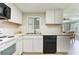 Bright kitchen with white cabinets and modern countertops provides a view to the dining area at 10600 Oleander Dr, Port Richey, FL 34668