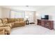Cozy living room with a sectional sofa, TV, and neutral decor at 10600 Oleander Dr, Port Richey, FL 34668