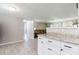Open floor plan featuring a living room and modern white cabinets with dark hardware in the kitchen at 10600 Oleander Dr, Port Richey, FL 34668