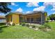 Beautiful backyard featuring a screened-in porch, lush lawn, and well-maintained landscaping at 11204 Biddeford Pl, New Port Richey, FL 34654