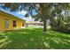 Grassy backyard featuring lush lawn and mature trees, creating a serene and private outdoor space at 11204 Biddeford Pl, New Port Richey, FL 34654