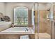 Bathroom soaking tub with view of backyard, shower and neutral tile at 11204 Biddeford Pl, New Port Richey, FL 34654