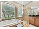 Bathroom featuring soaking tub with backyard view, and a glass door shower at 11204 Biddeford Pl, New Port Richey, FL 34654