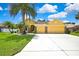 Charming yellow home featuring a manicured lawn, palm trees and a two-car garage at 11204 Biddeford Pl, New Port Richey, FL 34654