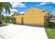 Home exterior showcasing a spacious three-car garage and a well-maintained driveway and lawn at 11204 Biddeford Pl, New Port Richey, FL 34654