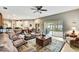 Open-concept living room with a large sectional, sliding glass doors, and a view of the screened lanai at 11204 Biddeford Pl, New Port Richey, FL 34654