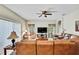 Spacious living room featuring a comfortable leather sectional, ceiling fan, and ample natural light at 11204 Biddeford Pl, New Port Richey, FL 34654