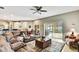 Comfortable living room with a ceiling fan, a large sectional couch, and sliding glass doors to a lanai at 11204 Biddeford Pl, New Port Richey, FL 34654