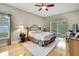 Serene main bedroom with wood floors, a king-sized bed, and sliding glass doors to the lanai at 11204 Biddeford Pl, New Port Richey, FL 34654
