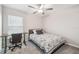 Cozy bedroom with a ceiling fan, a window with blinds, and a desk for work or study at 11395 Lavender Loop, Spring Hill, FL 34609