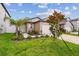 Inviting home exterior with a tidy lawn, young trees, and a paved walkway leading to the front door at 11395 Lavender Loop, Spring Hill, FL 34609