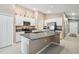 Spacious kitchen with granite countertops, white cabinetry, stainless steel appliances, and a large center island at 11395 Lavender Loop, Spring Hill, FL 34609