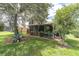 Inviting screened-in patio with a lush backyard and mature trees for privacy at 11418 Tee Time Cir, New Port Richey, FL 34654